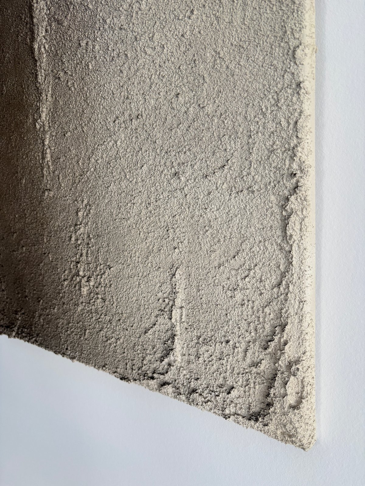 Nahaufnahme einer Bildecke mit grober Strukturoberfläche in Beige-Grau