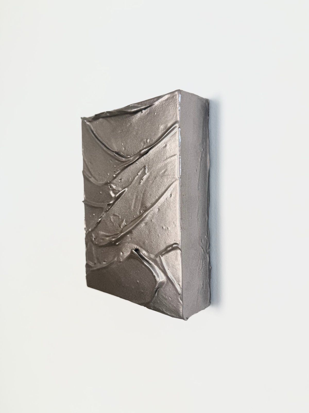 Kleines skulpturales Musterstück in Silber-Metallic vor weißem Hintergrund